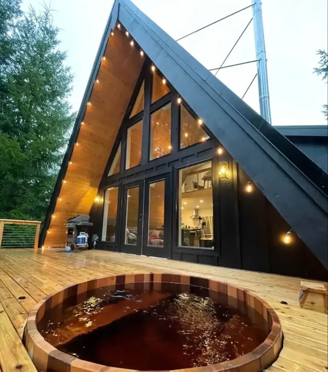 A-frame kuća sa drvenom kadom u dvorištu